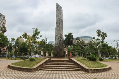 Asuncion, Paraguay 'daki yemyeşil çimlerin arasında belirgin bir şekilde duran dikkate değer taş bir yapı, bulutlu bir öğleden sonra yerel kültür mirasını ve tarihini yansıtıyor..