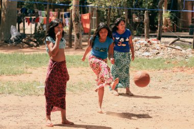Asuncion, Paraguay - 21 Ağustos 2023: Üç genç kız Paraguay 'ın kırsal kesimlerinde basketbol oynamaktan zevk alıyor, sıcak bir günde arkadaşça bir yarışmaya girdiklerinde neşelerini ve enerjilerini sergiliyorlar.