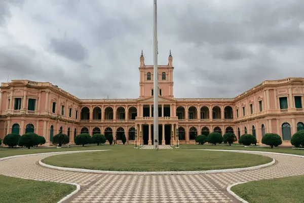 Asuncion, Paraguay 'daki büyük bir sömürge binası görkemli bir şekilde yemyeşil bahçeleri ve simetrik yolları var, hepsi de bulutlu bir gökyüzünün altında. Mimari zengin tarihi yansıtır..