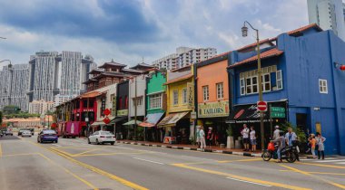 Singapur, Singapur - 20 Mayıs 2023: Renkli miras binaları Singapur Merkez Caddesi 'nde karamsar bir gökyüzü altında yayalar ve araçlarla dolup taşıyor..