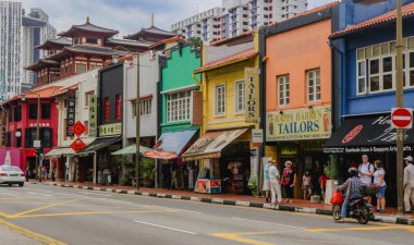Singapur, Singapur - 20 Mayıs 2023: Singapur 'un Merkez Bölgesi' nin caddelerini çevreleyen renkli binalar, yerel dükkanları ve hareketli bir şehir ortamında canlı yaya trafiğini gözler önüne seriyor.
