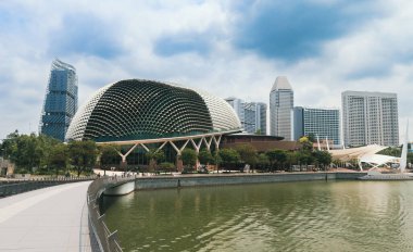 Singapur 'un canlı silueti, nehrin sakin suları yakınlarındaki yemyeşil yemyeşil çağın yanında modern mimariyi sergiliyor..