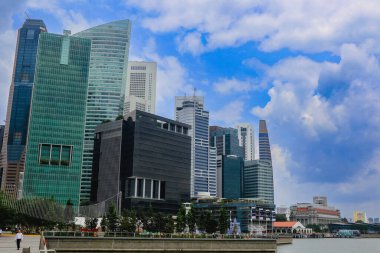 Uzun, parlak gökdelenler Singapur 'un rıhtımında, canlı bir gökyüzü altında modern mimari sergileniyor..