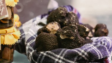 İtalya 'daki Alba Truffle Festivali' nde, ziyaretçiler kumaş üzerinde sergilenen çeşitli taze trüf mantarlarını keşfediyorlar..