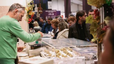 Alba, İtalya - 27 Ekim 2024: İtalya 'daki Alba Truffle Festivali' nde katılımcılar satıcılarla uğraşırken çeşitli mantar lezzetlerini keşfettiler. Canlı atmosfer, bölgenin zengin mutfak kültürünü gözler önüne seriyor..