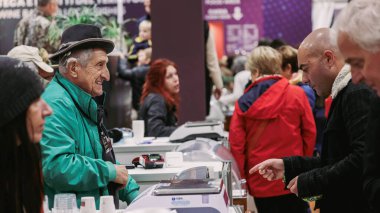 Alba, İtalya - 27 Ekim 2024: İtalya 'daki Alba Yer Mantarı Festivali' nde katılımcılar masaların etrafında toplanarak hikayeler ve yer mantarları satın alıyorlar. İnsanlar mutfak zevklerini ve yerel ikramları keşfederken atmosfer canlı..