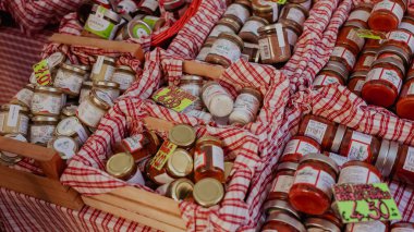 Alba, İtalya - 27 Ekim 2024: Ziyaretçiler, Alba Truffle Festivali 'nde canlı kavanozlarda sergilenen çeşitli mantar konserveleri ve sosların tadını çıkarıyorlar..