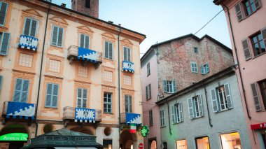 Alba, İtalya - 27 Ekim 2024: Alacakaranlık, İtalya 'nın Alba kentindeki büyüleyici binalara hafif bir ışık saçtı.