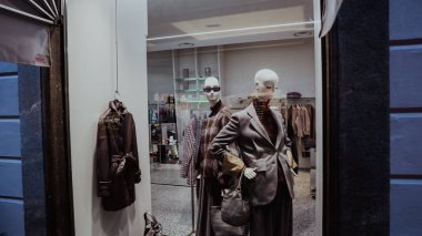 Alba, İtalya - 27 Ekim 2024: Mankenler en son moda trendlerini Alba 'daki bir mağazada sergiliyorlar. Dükkan şık bir atmosferi olan çağdaş bir alışveriş deneyimi sunuyor..