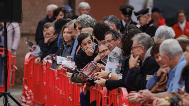 Alba, İtalya - 27 Ekim 2024: İnsanlar canlı bir etkinlik sırasında Alba, İtalya 'da bir bariyerin arkasında toplanıyor, kahkaha ve heyecan paylaşıyorlar. Atmosfer beklentiyle dolu..