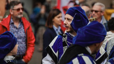 Alba, İtalya - 27 Ekim 2024: Geleneksel olarak giyinmiş kişiler, İtalya 'nın Alba kentinde düzenlenen canlı festivalde izleyicilerle etkileşime girerek yerel kültür ve toplum ruhunu ilgi çekici bir atmosferde sergilediler..