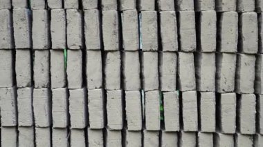 İşlenmemiş tuğlalar, kalıplar ve doğal kurutma işleminden sonra düzenli bir şekilde istiflenir..