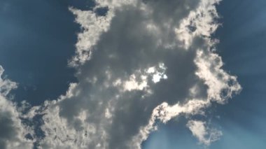 Yoğun bulutlar, mavi gökyüzünde güçlü bir şekilde parlayan güneşi örtmek için hareket etmeye başladı..