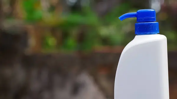 Yakın çekim kapaklı beyaz plastik şişe kullanıldı. Arka planda bulanık fotokopi alanı konsepti var..