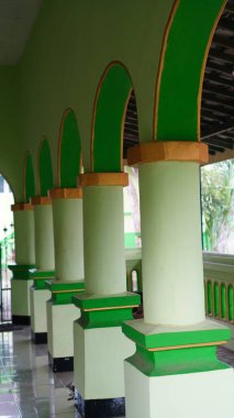 Bir binanın üzerindeki birkaç basit eğri sütun renkli yeşil ve sarı renklidir..