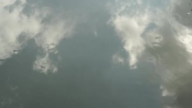 Gökyüzünün yansıması ve akan suyun yüzeyindeki bulutlar..