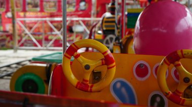 Sarı oyuncak direksiyon, oyun alanının kırmızı rengiyle birleşir.