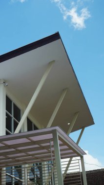 Mavi gökyüzü arkaplanı olan bir evin teras binası.