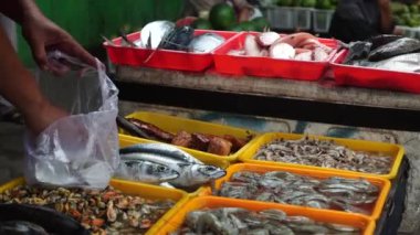 Geleneksel pazarlarda çeşitli taze balıklar hazırlanıyor ve sergileniyor.