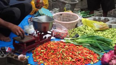 Geleneksel pazarlardaki sebze tüccarları müşteriler için biber tartıyorlar.