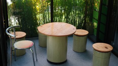 Yuvarlak masa ve cam odadaki kullanılmış paletlerden sandalyeler.