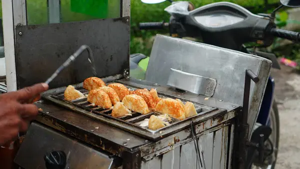 street vendors are cooking traditional Serabi cakes or Rangin on hot molds