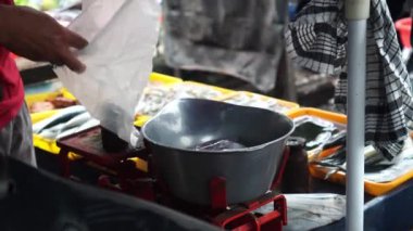 Taze balık, pazar satıcısı tarttıktan sonra plastik poşetlere doldurulur.