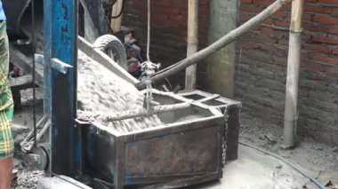 Beton karışımı, beton karıştırma makinesinden vinç kaldırma küvetine dökülüyor..