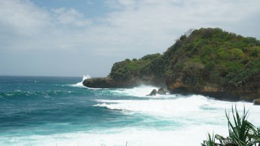 Sarp kayalıkları olan canlı mavi bir okyanus. Doğanın inanılmaz güzelliğini ön plana çıkarıyor. Görsel olarak çarpıcı bir kompozisyon oluşturuyor..