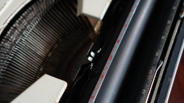 Klasik bir daktilo mekanizmasının yakın plan görüntüsü, yazı çubuklarını ve kılavuzunu gösterir. Makine, dijital çağdan önce kullanılan klasik daktiloların tipik bir özelliği olan fonksiyonel tasarımla mekanik karmaşıklığı birleştirir..