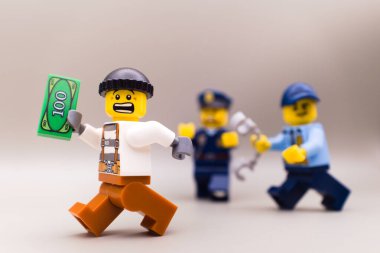 Varşova, Polonya, 30 Eylül 2023 Bir bankadan para çalan bir hırsızı kovalayan polisler. Lego minyatür figürleri ve diğer tüm tuğlalar LEGO GROUP tarafından yapıldı..