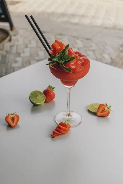 Strawberry daiquiri cocktail, decorated with strawberry fruit and lime slices