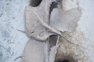 Lekeleri ve çatlakları olan eski beton bir duvar dokusu, beyaz kabuk soyma arka planı.