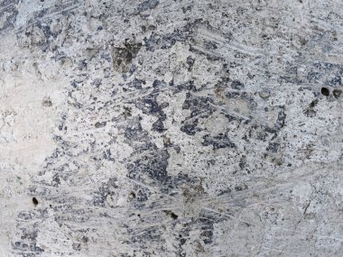 Lekeleri ve çatlakları olan eski beton bir duvar dokusu, beyaz kabuk soyma arka planı.