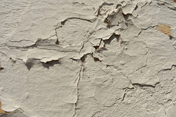 Lekeleri ve çatlakları olan eski beton bir duvar dokusu, beyaz kabuk soyma arka planı.