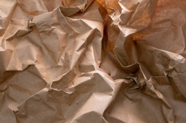 Geri dönüşümün özünü sembolize eden buruşuk bir el işi kağıdı arka planı - atıkların yeniden kullanılması ve azaltılması, sürdürülebilirliğin doku ve karakter ile harmanlanması, çevre dostu bir hatırlatma.