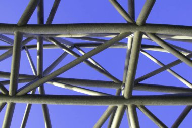 Renkli arka planda soyut metal figür, sanatsal kaynaklı metal borular, yapı iskelesi parçası