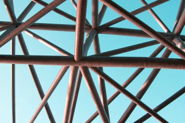 Renkli arka planda soyut metal figür, sanatsal kaynaklı metal borular, yapı iskelesi parçası