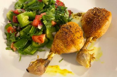 Beyaz tabakta sebze salatasıyla ızgara tavuk filetosu.