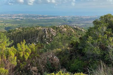 Dağın tepesinden şehre ve denize bak.