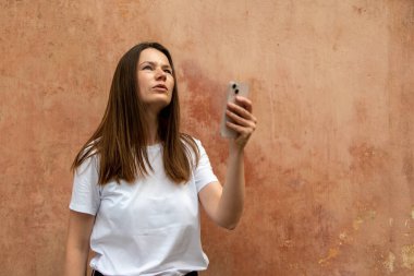 Güzel bir genç kadının portresi cep telefonuyla selfie çekiyor.