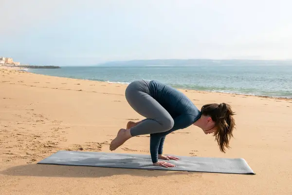 年轻迷人的女人在海滩上练习瑜伽 健康生活方式概念 — 图库照片