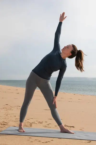 年轻迷人的女人在海边练瑜伽 健康生活方式概念 — 图库照片
