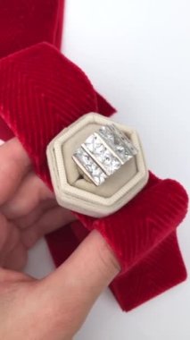 Beyaz arka planda bir kadının elindeki eşsiz mücevher yüzüğü, klasik mücevher konsepti, online bir kuyumcu için promosyon videosu.