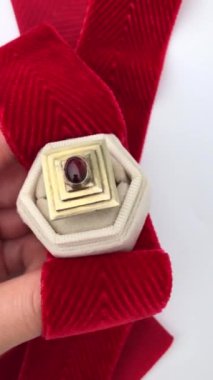 Beyaz arka planda bir kadının elindeki eşsiz mücevher yüzüğü, klasik mücevher konsepti, online bir kuyumcu için promosyon videosu.