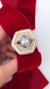 Beyaz arka planda bir kadının elindeki eşsiz mücevher yüzüğü, klasik mücevher konsepti, online bir kuyumcu için promosyon videosu.