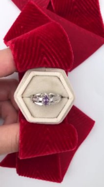 Beyaz arka planda bir kadının elindeki eşsiz mücevher yüzüğü, klasik mücevher konsepti, online bir kuyumcu için promosyon videosu.
