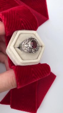 Beyaz arka planda bir kadının elindeki eşsiz mücevher yüzüğü, klasik mücevher konsepti, online bir kuyumcu için promosyon videosu.