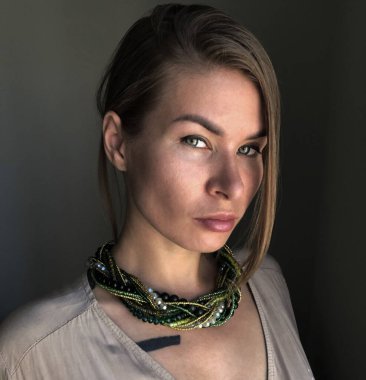 Sıra dışı bir kolye takmış genç bir kadının portresi.