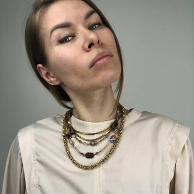 Sıra dışı bir kolye takmış genç bir kadının portresi.